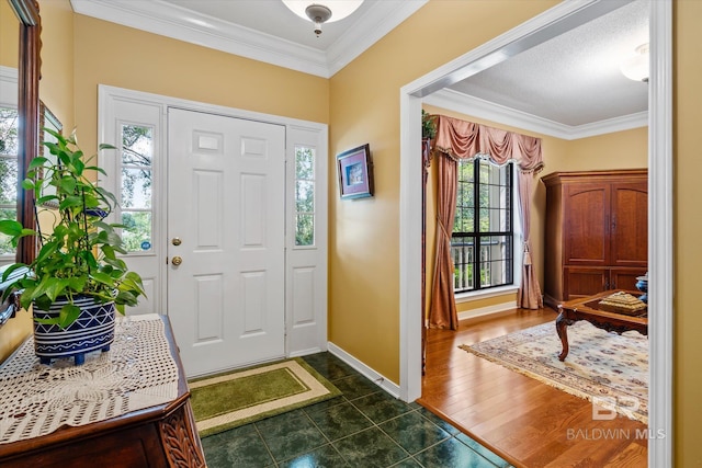 entrance foyer featuring dark wood-type flooring, ornamental molding, and a healthy amount of sunlight