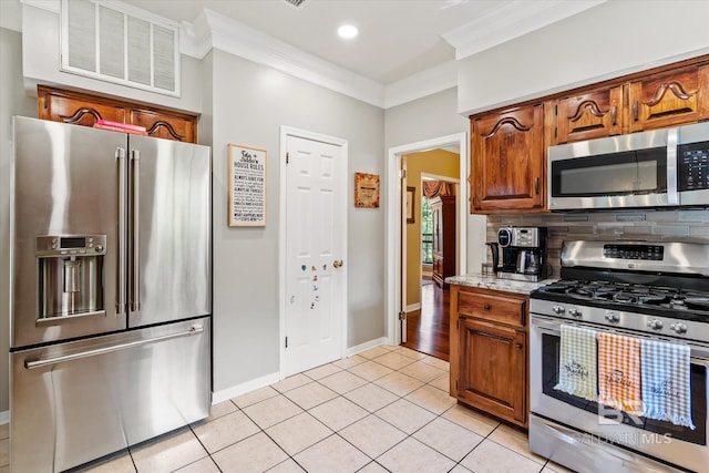 kitchen featuring appliances with stainless steel finishes, crown molding, light tile patterned floors, and decorative backsplash