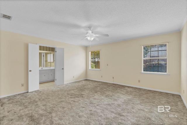 carpeted empty room with a textured ceiling and ceiling fan