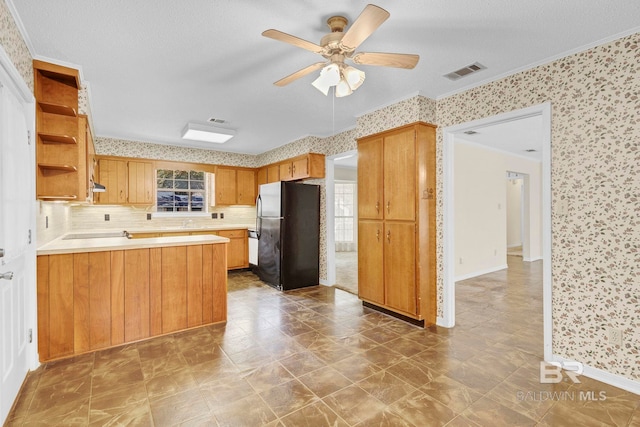 kitchen with crown molding, ceiling fan, black appliances, decorative backsplash, and kitchen peninsula