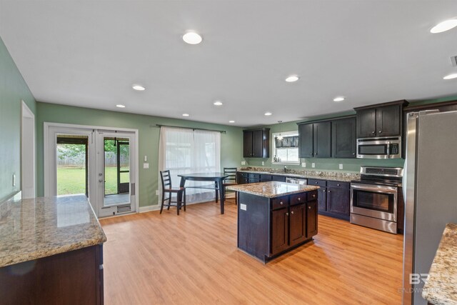 18971 Tralee Ct, Foley, AL 36535 - kitchen featuring appliances with stainless steel finishes, recessed lighting, a kitchen island, light wood-type flooring, and light stone countertops