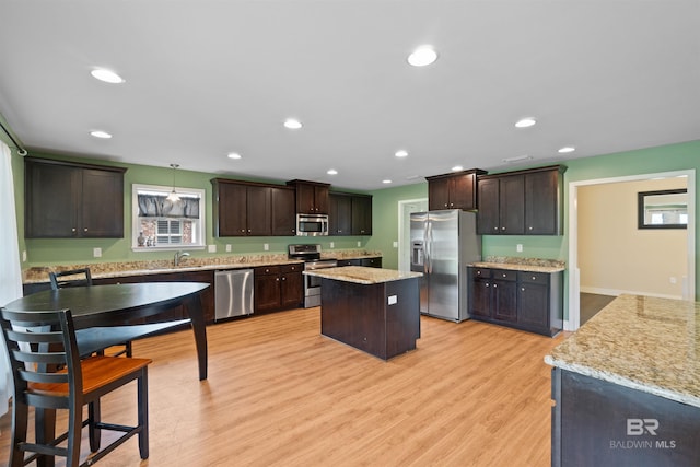 18971 Tralee Ct, Foley, AL 36535 - kitchen with stainless steel appliances, dark brown cabinets, a kitchen island, light wood-style floors, and recessed lighting