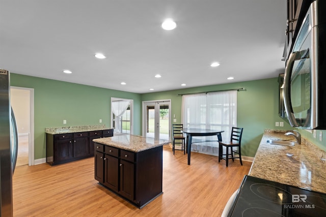 18971 Tralee Ct, Foley, AL 36535 - kitchen with a sink, freestanding refrigerator, light wood-type flooring, dark brown cabinets, and light stone countertops