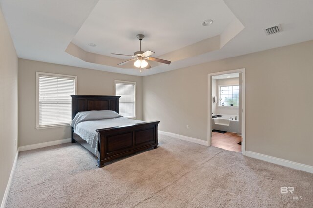 18971 Tralee Ct, Foley, AL 36535 - bedroom featuring a tray ceiling, carpet flooring, baseboards, ceiling fan, and connected bathroom