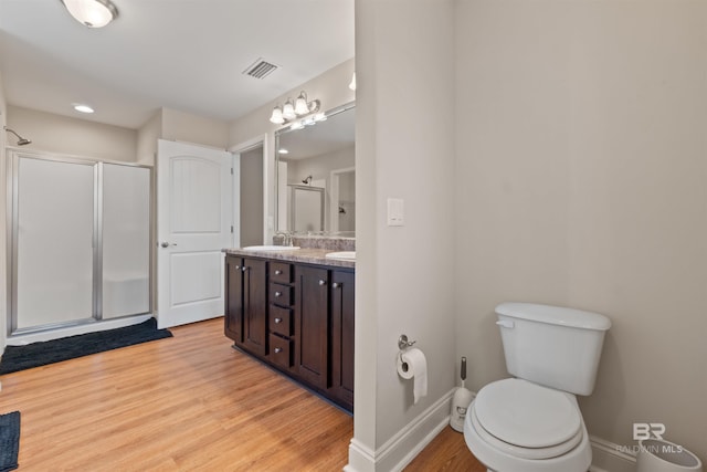 18971 Tralee Ct, Foley, AL 36535 - full bathroom featuring a shower stall, wood finished floors, baseboards, double vanity, and toilet