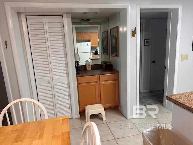 interior space featuring light tile patterned flooring and white refrigerator