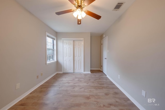 unfurnished bedroom featuring a closet, light wood-type flooring, and ceiling fan