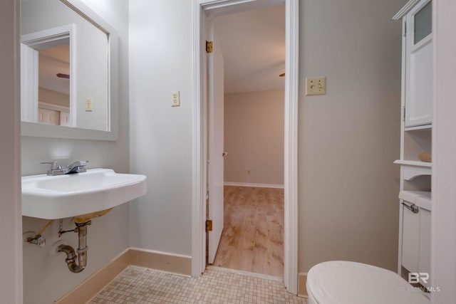 bathroom featuring toilet, sink, and hardwood / wood-style floors