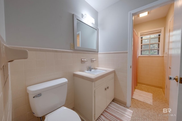 bathroom featuring tile walls, vanity, tile patterned floors, and toilet