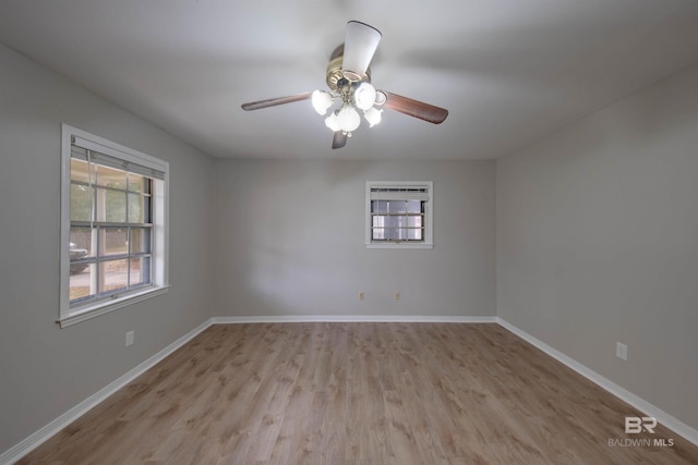 spare room with plenty of natural light, ceiling fan, and light hardwood / wood-style flooring