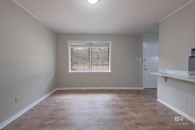 unfurnished room featuring light wood-type flooring and crown molding