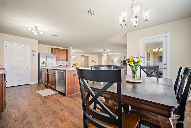 24189 Harvester Dr, Loxley, AL 36551 - dining space featuring dark wood-type flooring, a chandelier, and a ceiling fan