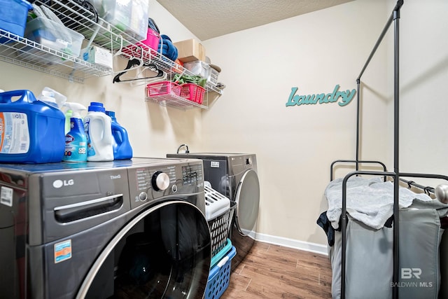 24189 Harvester Dr, Loxley, AL 36551 - laundry area featuring washer and dryer and wood finished floors