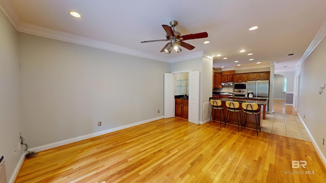 1651 Laurel St, Mobile, AL 36604 - living room with crown molding, ceiling fan, arched walkways, light wood-style floors, and baseboards