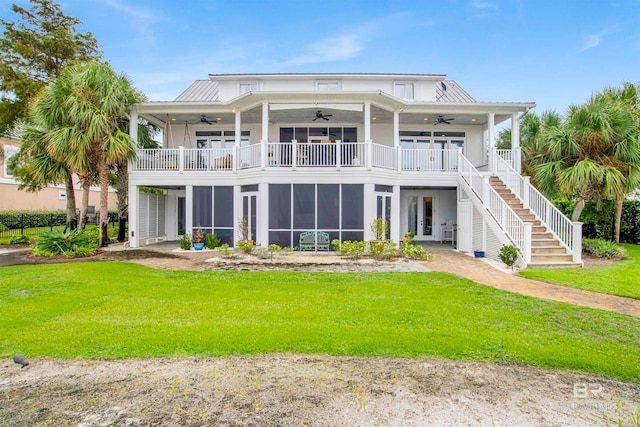 back of house with a lawn, a balcony, and ceiling fan