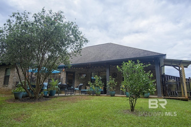 20752 Southwood St, Fairhope, AL 36532 - rear view of property featuring roof with shingles, a yard, and a patio