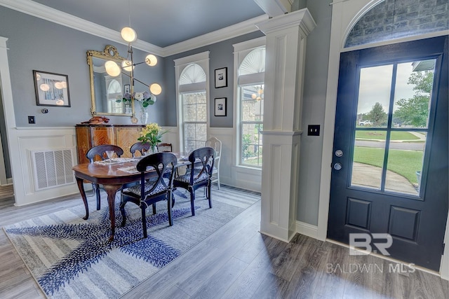 20752 Southwood St, Fairhope, AL 36532 - dining space featuring ornate columns, a decorative wall, healthy amount of natural light, wood finished floors, and wainscoting