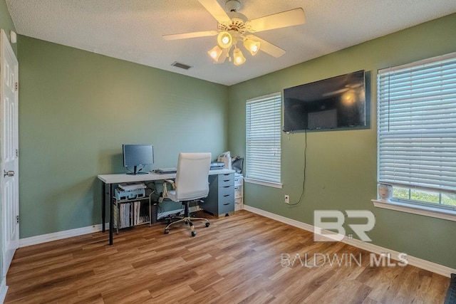 office area featuring ceiling fan, hardwood / wood-style floors, and a textured ceiling