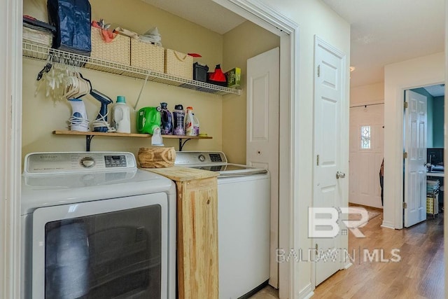 laundry room featuring washing machine and clothes dryer and hardwood / wood-style floors