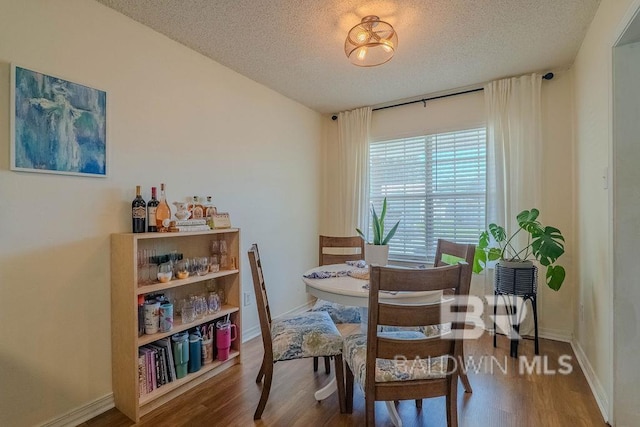 dining room with hardwood / wood-style floors and a textured ceiling