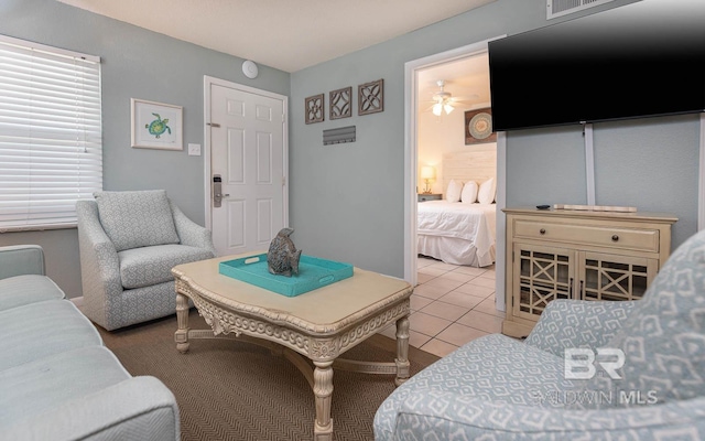 living room featuring ceiling fan and tile patterned floors