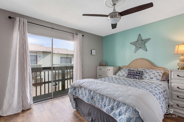 bedroom featuring access to outside, a textured ceiling, ceiling fan, and wood finished floors