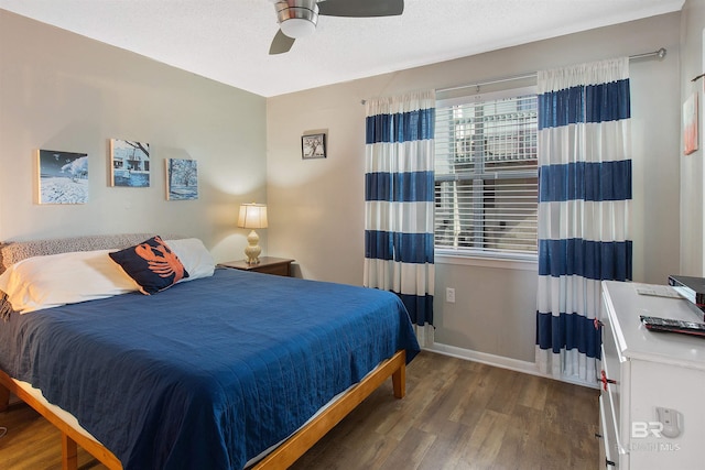 bedroom featuring ceiling fan, a textured ceiling, baseboards, and wood finished floors