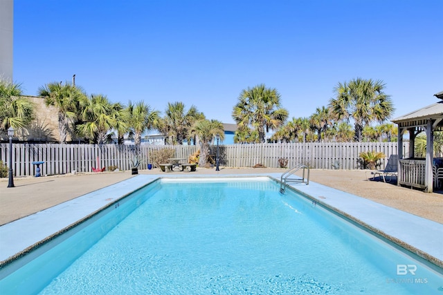 view of pool featuring a fenced in pool, a patio area, a fenced backyard, and a gazebo