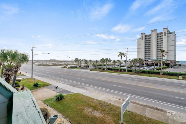 view of road featuring sidewalks, curbs, and street lights