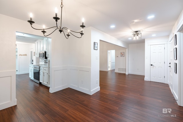 unfurnished dining area featuring dark hardwood / wood-style flooring and a chandelier