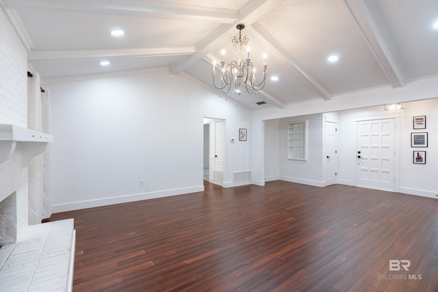 unfurnished living room featuring a brick fireplace, lofted ceiling with beams, dark hardwood / wood-style flooring, and an inviting chandelier