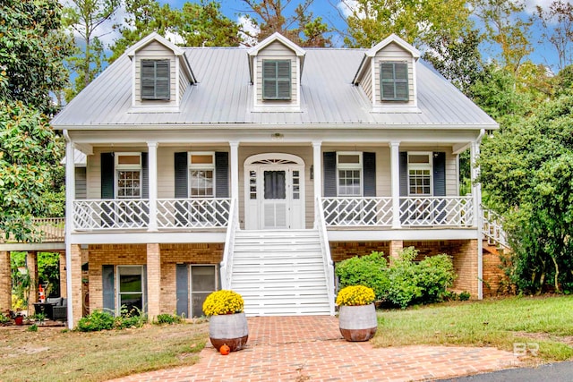 cape cod house featuring a porch and a front lawn