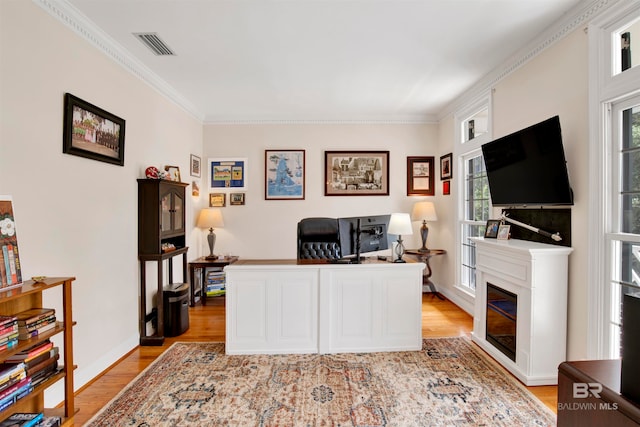 home office featuring ornamental molding and light hardwood / wood-style flooring