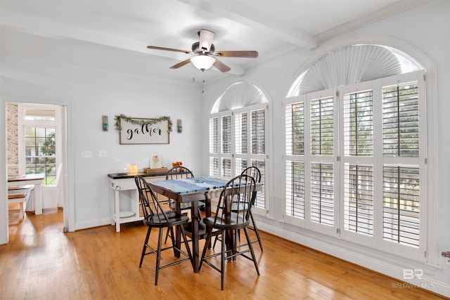 dining space with beamed ceiling, ornamental molding, light wood-type flooring, and ceiling fan