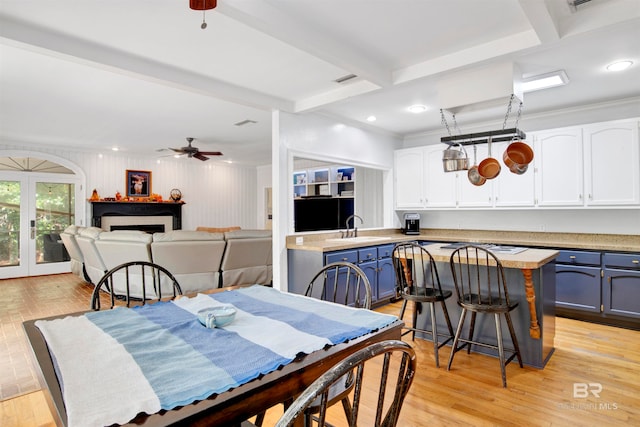 dining room with sink, ceiling fan, beamed ceiling, and light hardwood / wood-style flooring