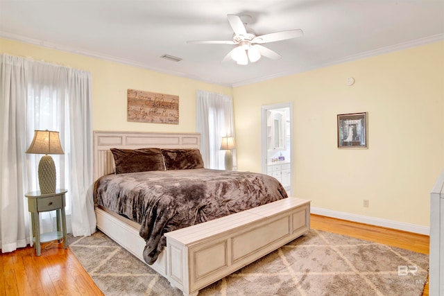 bedroom with light hardwood / wood-style flooring, multiple windows, ensuite bathroom, and ceiling fan