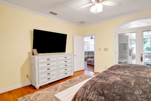 bedroom featuring ornamental molding, multiple windows, and light wood-type flooring