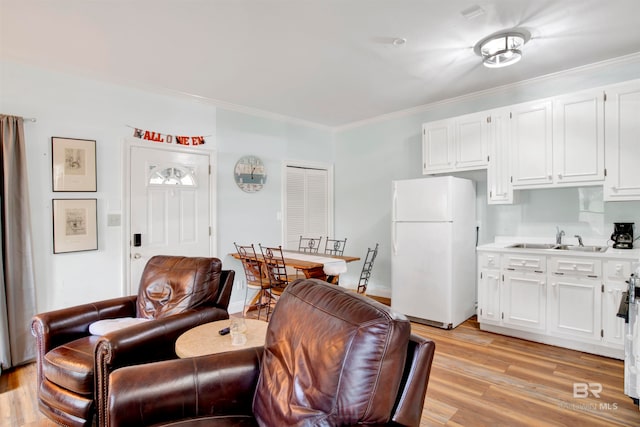 living room featuring ornamental molding, sink, and light wood-type flooring