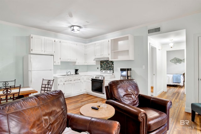 kitchen with crown molding, white cabinets, white fridge, and electric range oven