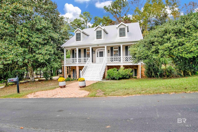 cape cod-style house featuring a front yard and a porch