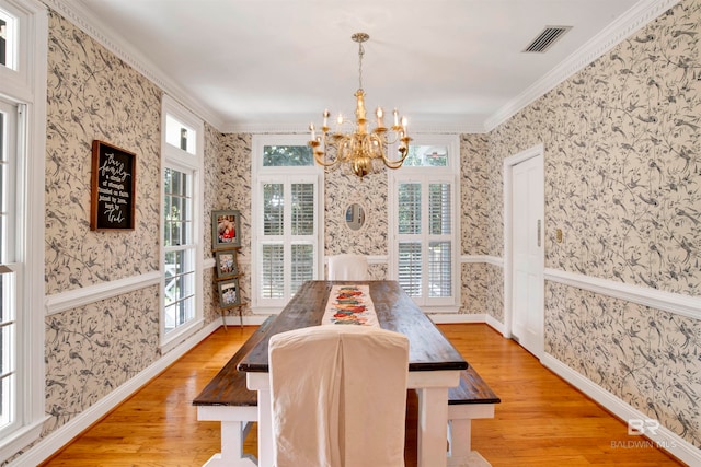 dining room featuring an inviting chandelier, ornamental molding, and light wood-type flooring