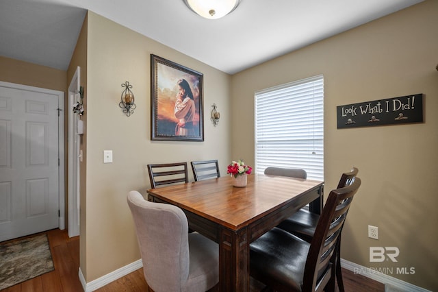 dining space featuring baseboards and wood finished floors