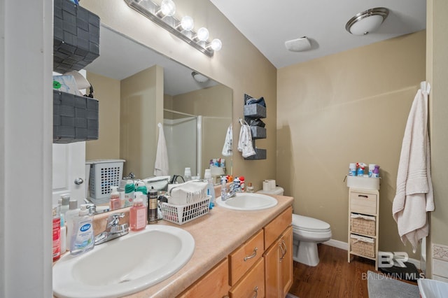 full bathroom with a sink, toilet, wood finished floors, and a shower stall