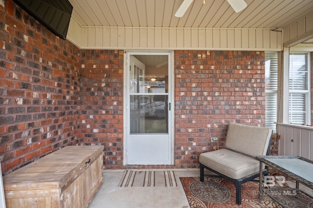 doorway to property featuring brick siding and a patio