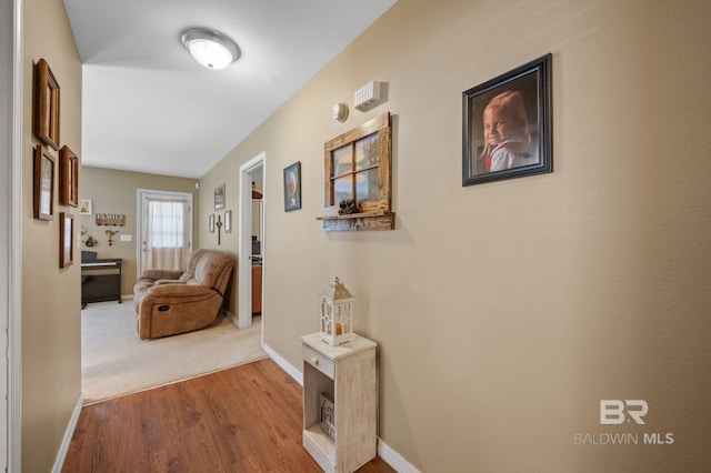 corridor featuring wood finished floors and baseboards