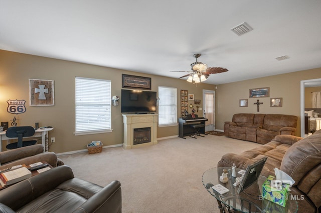 living room with a wealth of natural light, visible vents, and light carpet