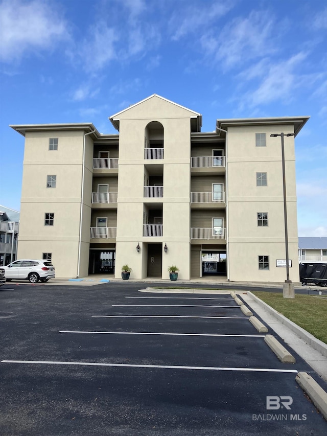 view of building exterior with uncovered parking