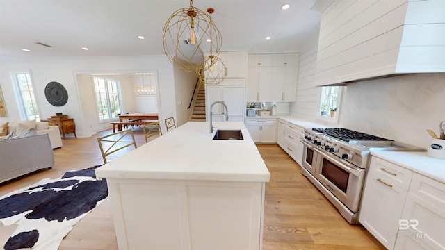 140 S Mcgregor Ave # E, Mobile, AL 36608 - kitchen with range with two ovens, a sink, premium range hood, healthy amount of natural light, and recessed lighting