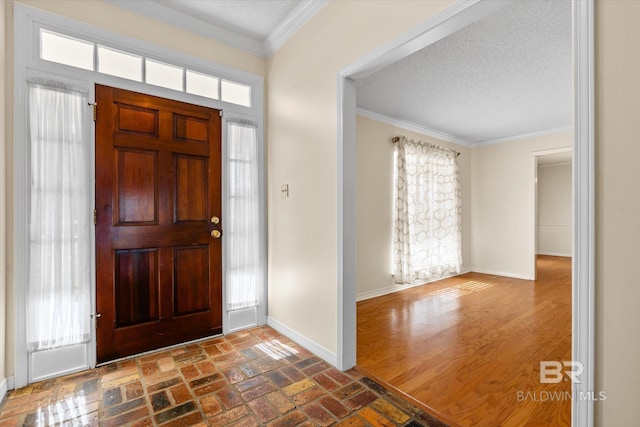 entryway featuring dark hardwood / wood-style floors, ornamental molding, and a textured ceiling