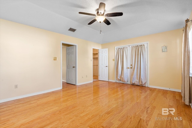 unfurnished bedroom with a textured ceiling, light hardwood / wood-style floors, and ceiling fan